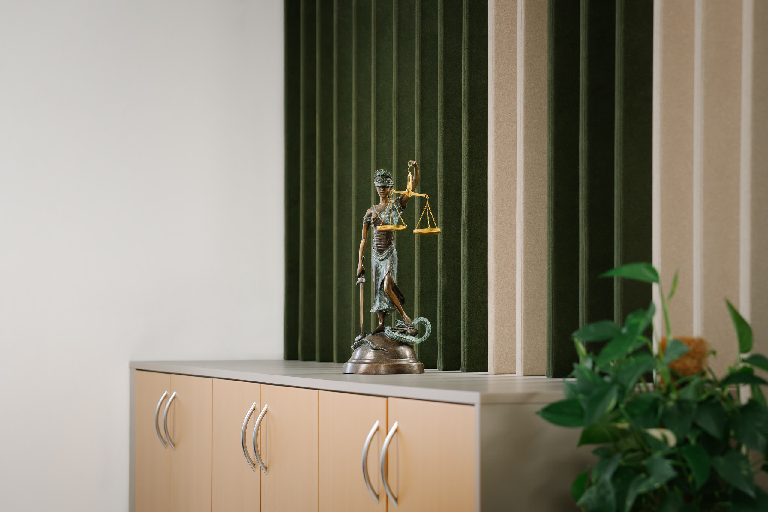 Justitia-Statue und Pflanze in der Kanzlei