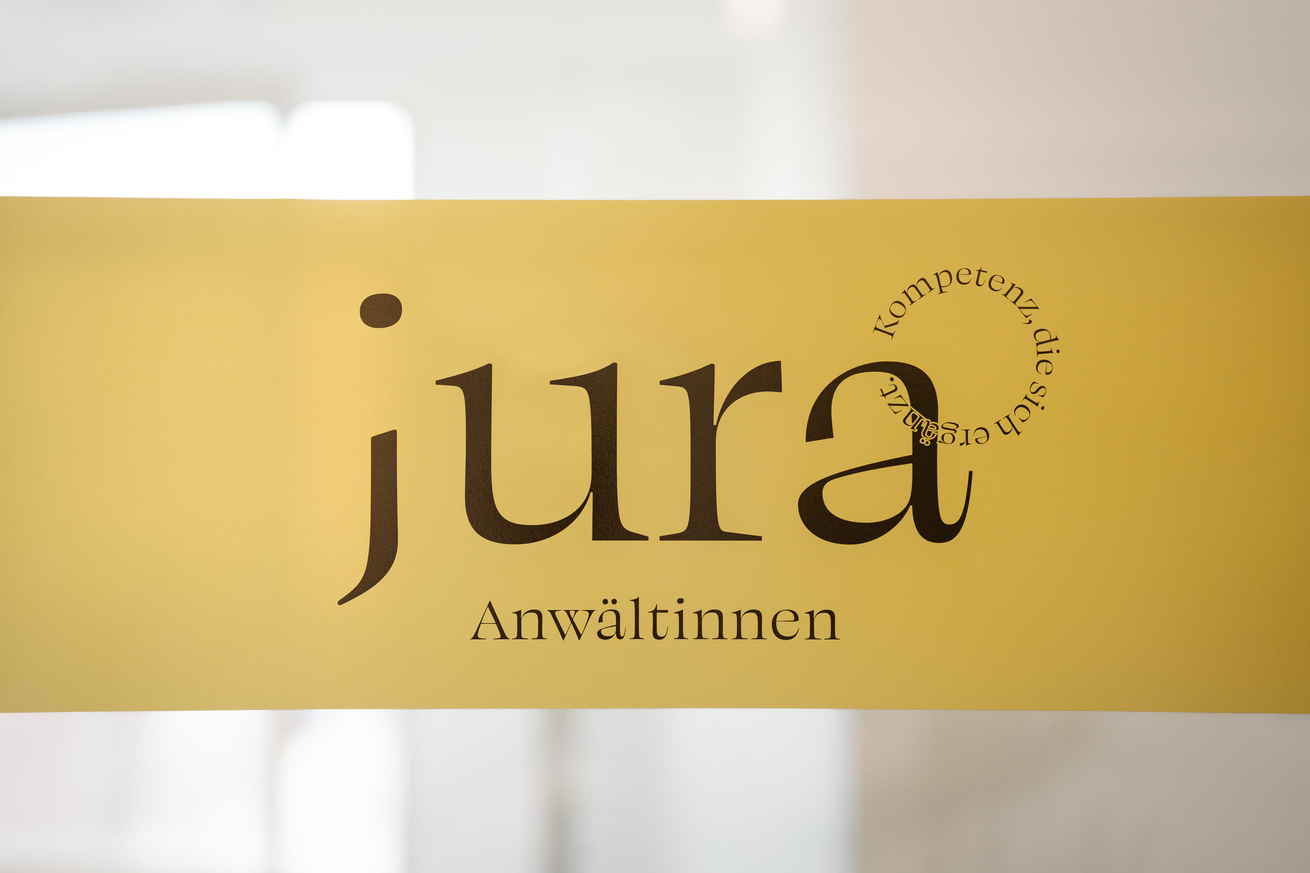 Jura Anwältinnen Schriftzug auf goldfarbenem Hintergrund